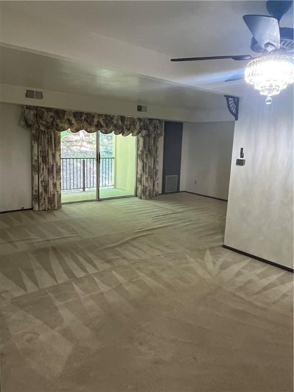 carpeted empty room featuring visible vents and a ceiling fan