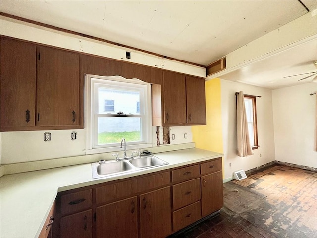 kitchen with light countertops, a ceiling fan, visible vents, and a sink