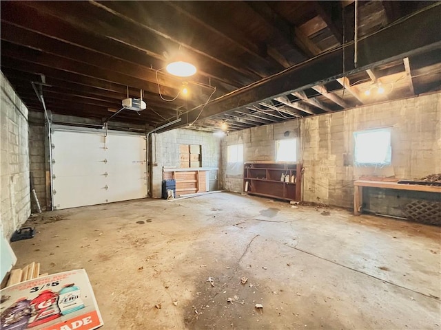 garage featuring a garage door opener and concrete block wall