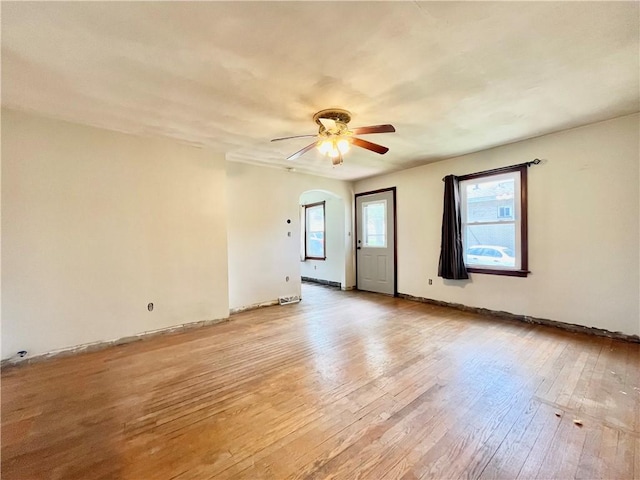unfurnished room featuring baseboards, a ceiling fan, and light wood-style flooring