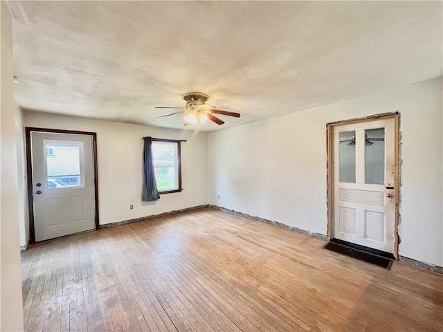 spare room with ceiling fan, baseboards, and light wood finished floors