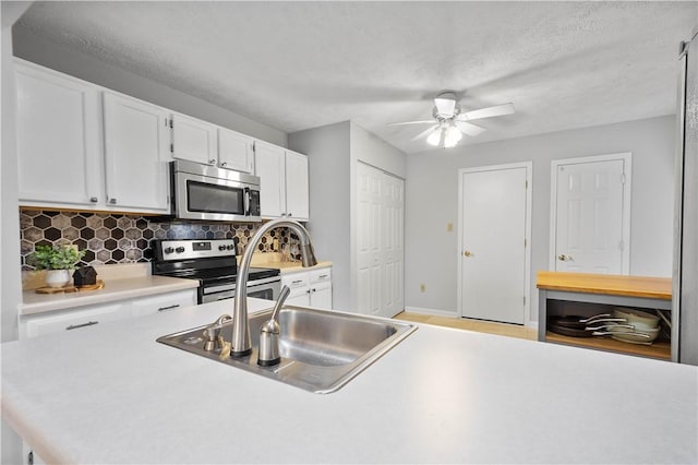 1470 Yorktown Dr, Cecil, PA 15055 - kitchen with decorative backsplash, light countertops, white cabinetry, a ceiling fan, and stainless steel appliances