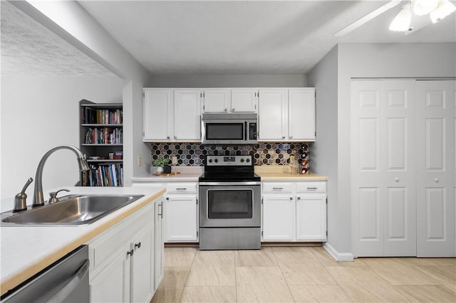 1470 Yorktown Dr, Cecil, PA 15055 - kitchen featuring backsplash, appliances with stainless steel finishes, a sink, light countertops, and white cabinets