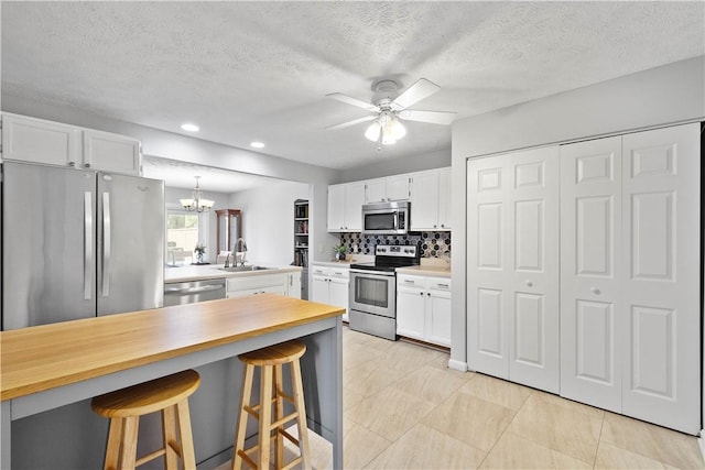 1470 Yorktown Dr, Cecil, PA 15055 - kitchen featuring a sink, white cabinetry, a kitchen bar, and stainless steel appliances