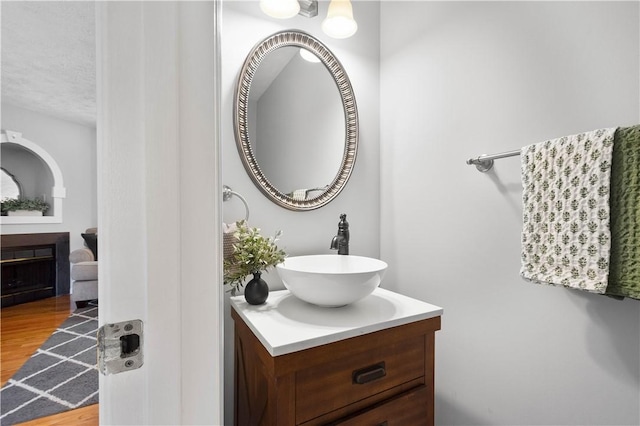 1470 Yorktown Dr, Cecil, PA 15055 - bathroom featuring vanity, a fireplace, a textured ceiling, and wood finished floors