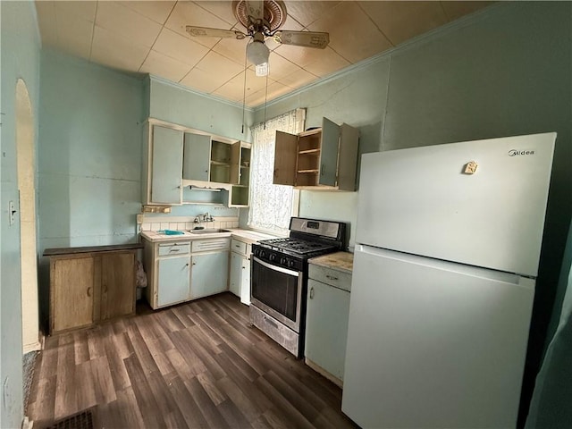kitchen featuring open shelves, a sink, gas stove, light countertops, and freestanding refrigerator