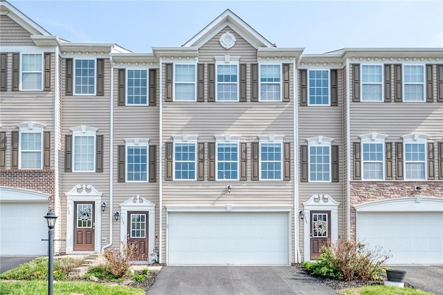 townhome / multi-family property with an attached garage and driveway