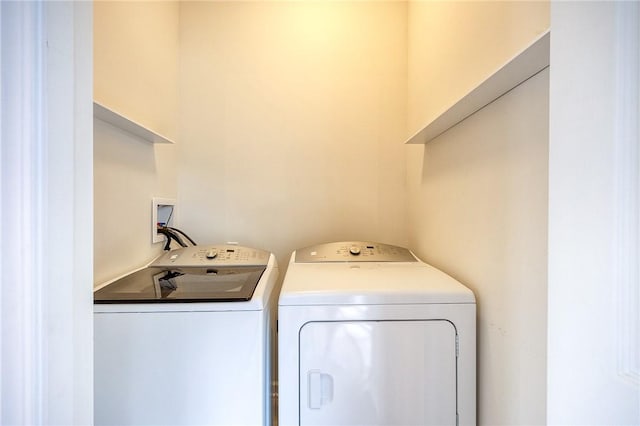 clothes washing area featuring laundry area and washer and clothes dryer