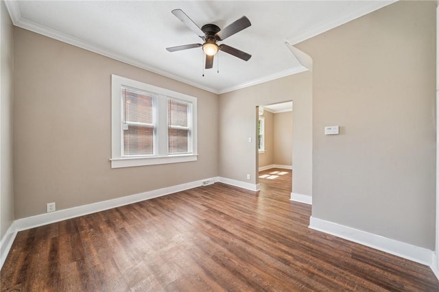 unfurnished room featuring crown molding, baseboards, dark wood-style floors, and ceiling fan