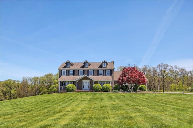 traditional-style home with a chimney and a front yard