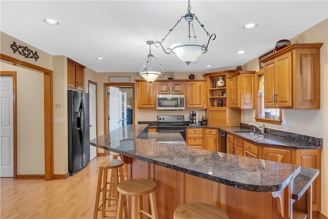 kitchen featuring a kitchen island, open shelves, a sink, black appliances, and light wood finished floors