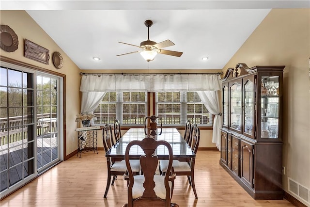 dining area featuring visible vents, baseboards, light wood-style flooring, and lofted ceiling