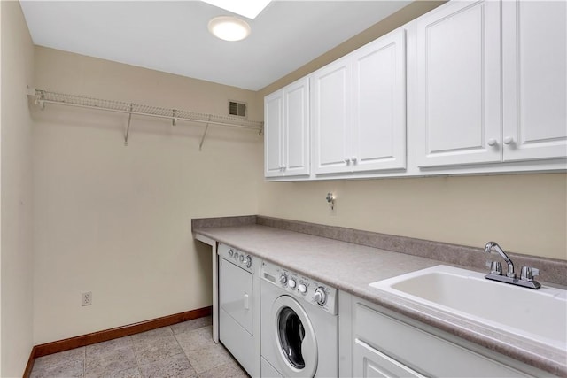 washroom featuring washer and dryer, cabinet space, a sink, baseboards, and visible vents