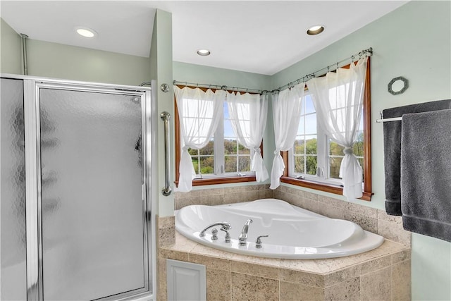 bathroom featuring a shower stall and a bath