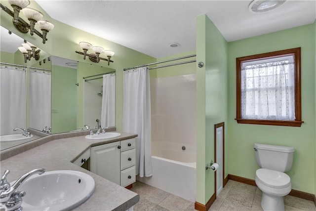 bathroom with toilet, baseboards, a sink, and shower / bath combo with shower curtain