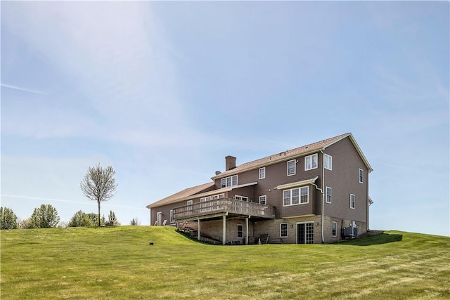 rear view of property with central air condition unit, a yard, a chimney, and a deck