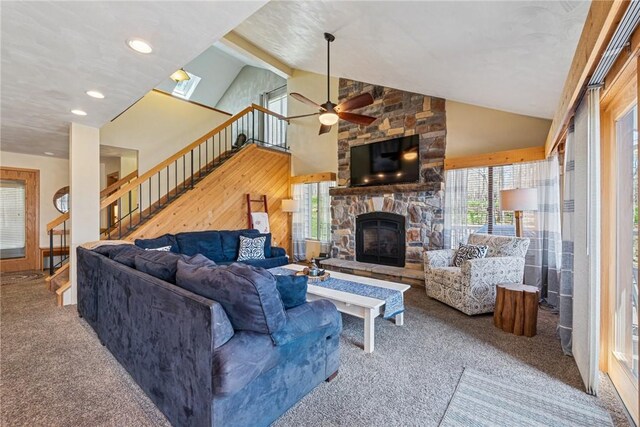 carpeted living room featuring a ceiling fan, a fireplace, stairway, high vaulted ceiling, and recessed lighting