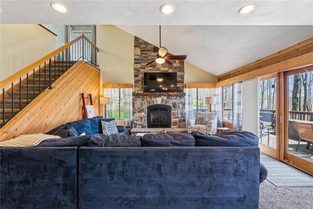 carpeted living room featuring ceiling fan, a stone fireplace, vaulted ceiling, stairs, and recessed lighting