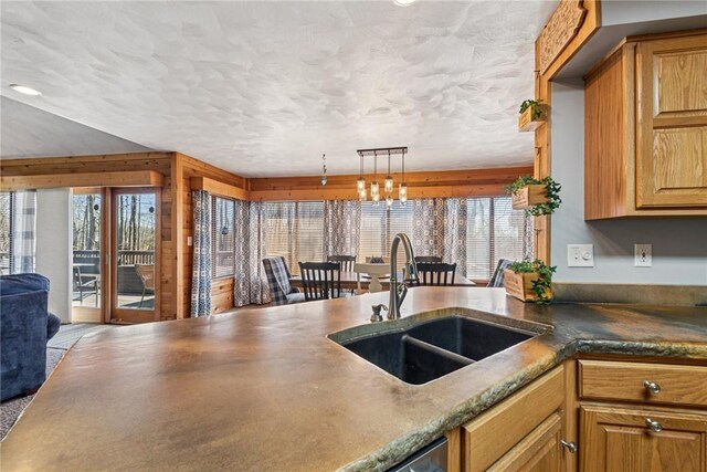 kitchen featuring plenty of natural light, a sink, open floor plan, and dark countertops