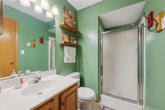 bathroom with vanity, tile patterned flooring, a stall shower, and toilet