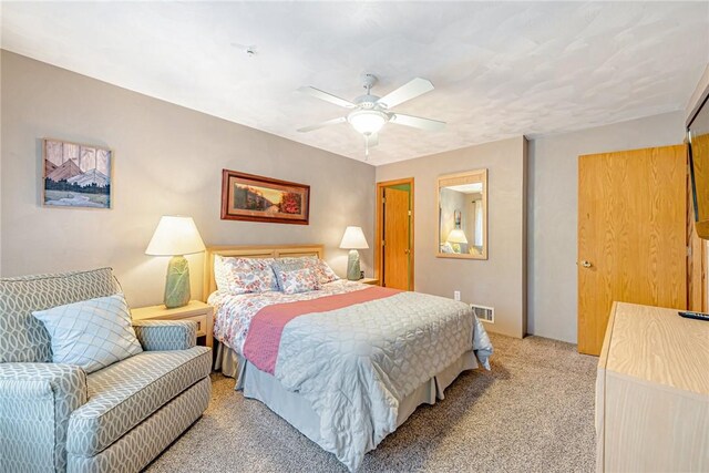 bedroom with ceiling fan, light carpet, and visible vents