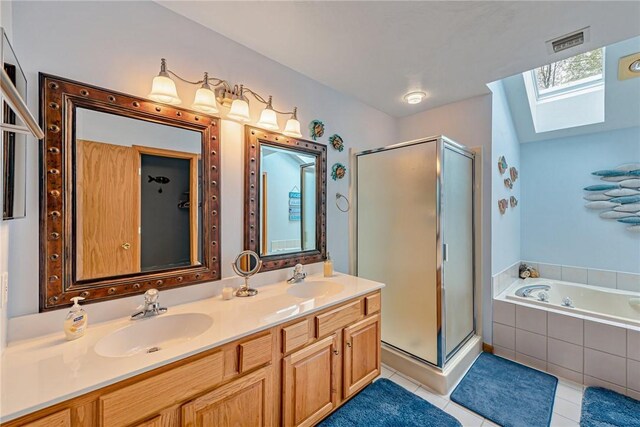 bathroom featuring a skylight, visible vents, a sink, and a stall shower
