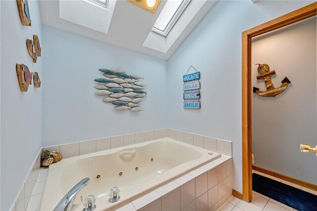 bathroom featuring toilet, a skylight, a tub with jets, and tile patterned flooring