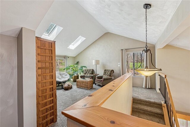 interior space with carpet flooring and vaulted ceiling with skylight