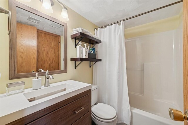 bathroom with toilet, visible vents, shower / tub combo with curtain, and vanity