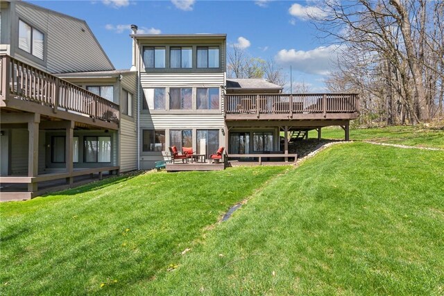 rear view of property featuring a yard and a deck