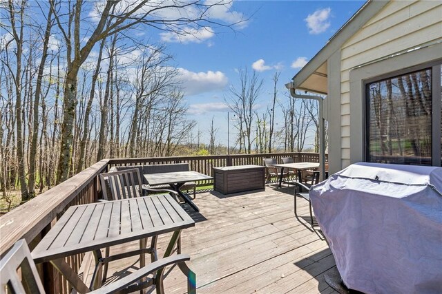deck featuring outdoor dining area and a grill