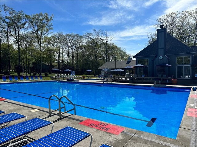 pool featuring an outdoor structure and a patio area