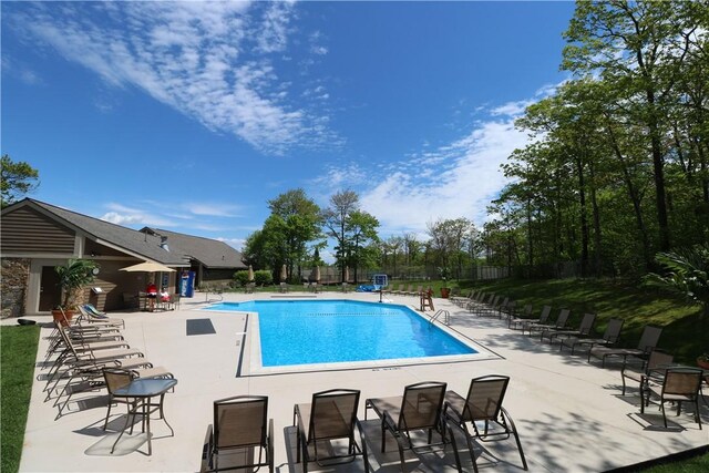 community pool with fence and a patio area
