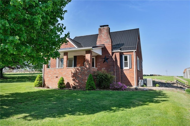244 S Rebecca St, Saxonburg Boro, PA 16056 - view of front of house featuring brick siding, a standing seam roof, a chimney, and a front yard