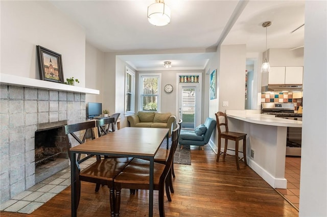 4004 Windsor St, Greenfield, PA 15217 - dining area with baseboards, a brick fireplace, dark wood-style flooring, and visible vents