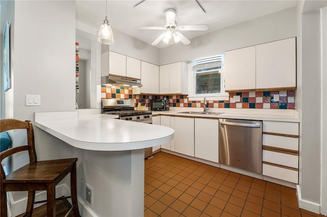 4004 Windsor St, Greenfield, PA 15217 - kitchen with backsplash, appliances with stainless steel finishes, a sink, a peninsula, and under cabinet range hood