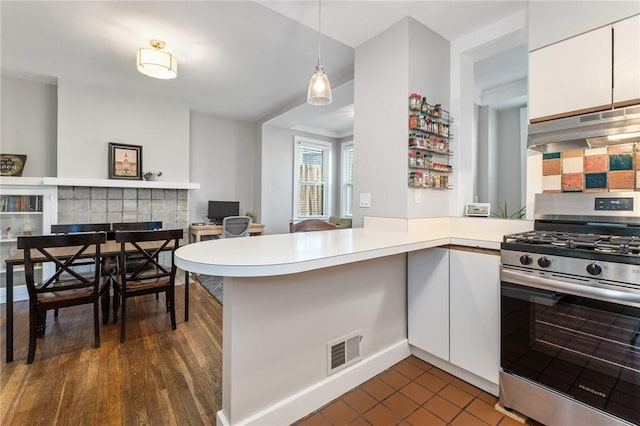 4004 Windsor St, Greenfield, PA 15217 - kitchen with visible vents, gas range, a peninsula, under cabinet range hood, and white cabinetry