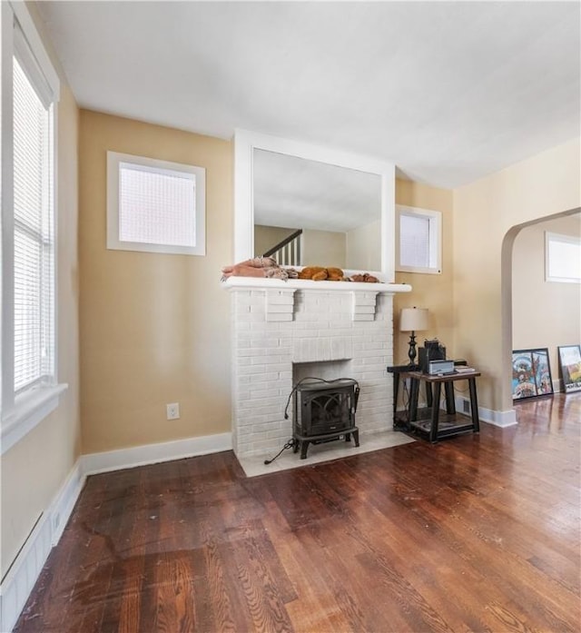 4128 Winterburn, Greenfield, PA 15207 - living area featuring plenty of natural light, a wood stove, arched walkways, and wood finished floors