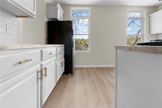 205 Berkley Ave, Forest Hills Boro, PA 15221 - kitchen featuring white cabinets, freestanding refrigerator, light wood-type flooring, and a wealth of natural light