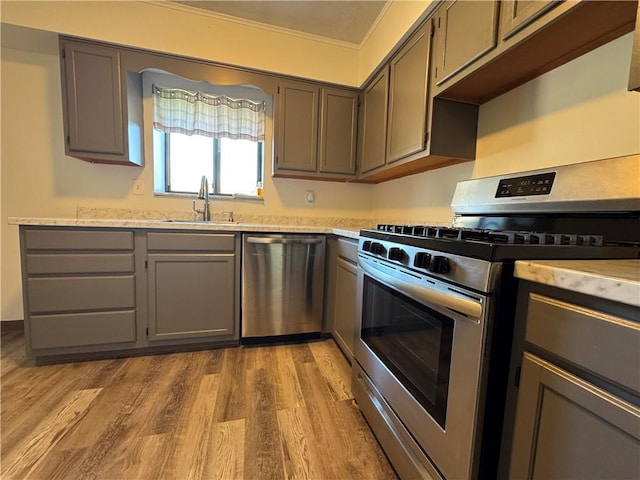 kitchen featuring gray cabinetry, stainless steel appliances, and a sink
