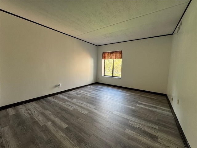 unfurnished room with baseboards, a textured ceiling, and wood finished floors