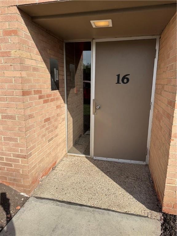 view of exterior entry featuring brick siding