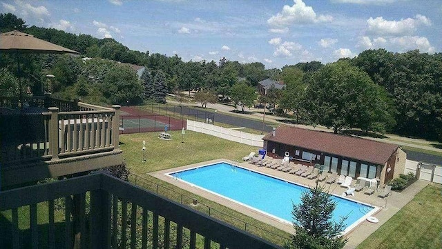 pool with a patio area, fence, and a yard