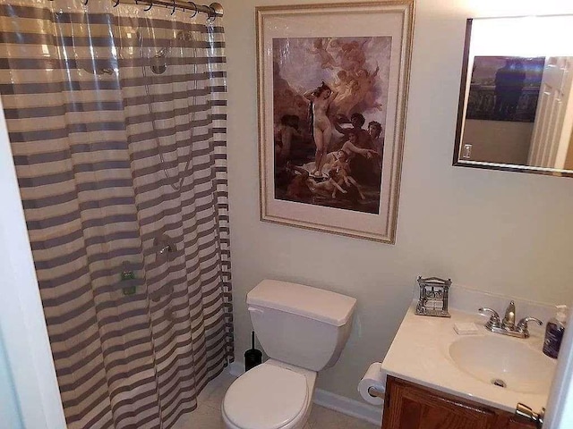 full bathroom featuring vanity, a tile shower, and toilet