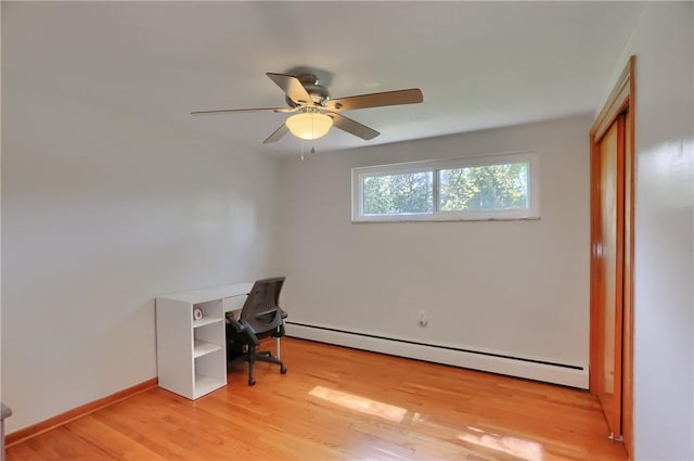 office space featuring ceiling fan, a baseboard heating unit, baseboards, and light wood-style floors