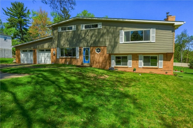view of front of house featuring driveway, a chimney, brick siding, a front lawn, and an attached garage