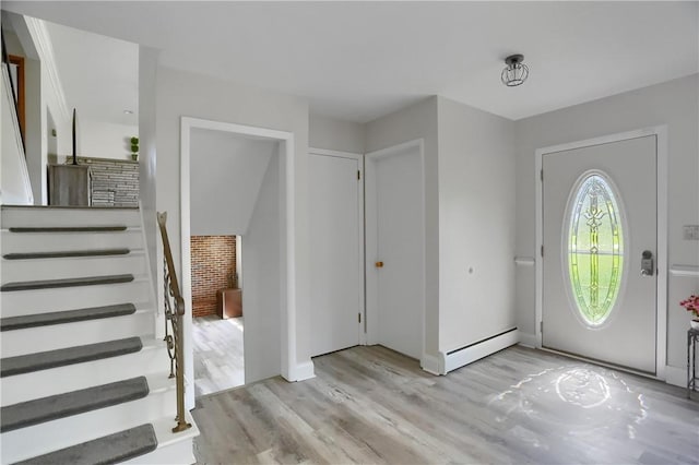 entryway with baseboards, a baseboard heating unit, and light wood-style flooring