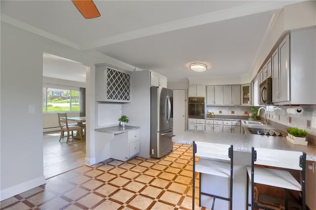 kitchen with crown molding, a breakfast bar, a sink, a peninsula, and black appliances