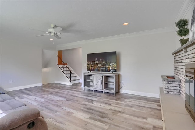 living room featuring stairs, ornamental molding, wood finished floors, and a fireplace