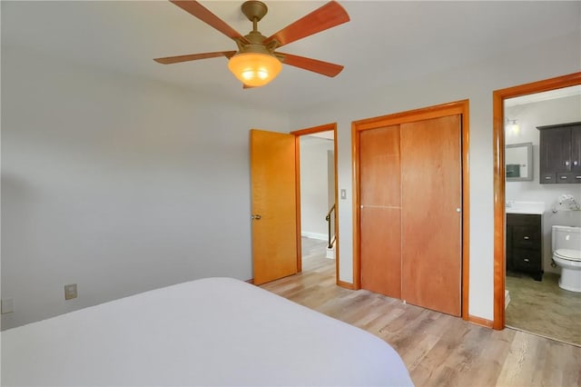 bedroom featuring a closet, baseboards, ceiling fan, connected bathroom, and light wood finished floors